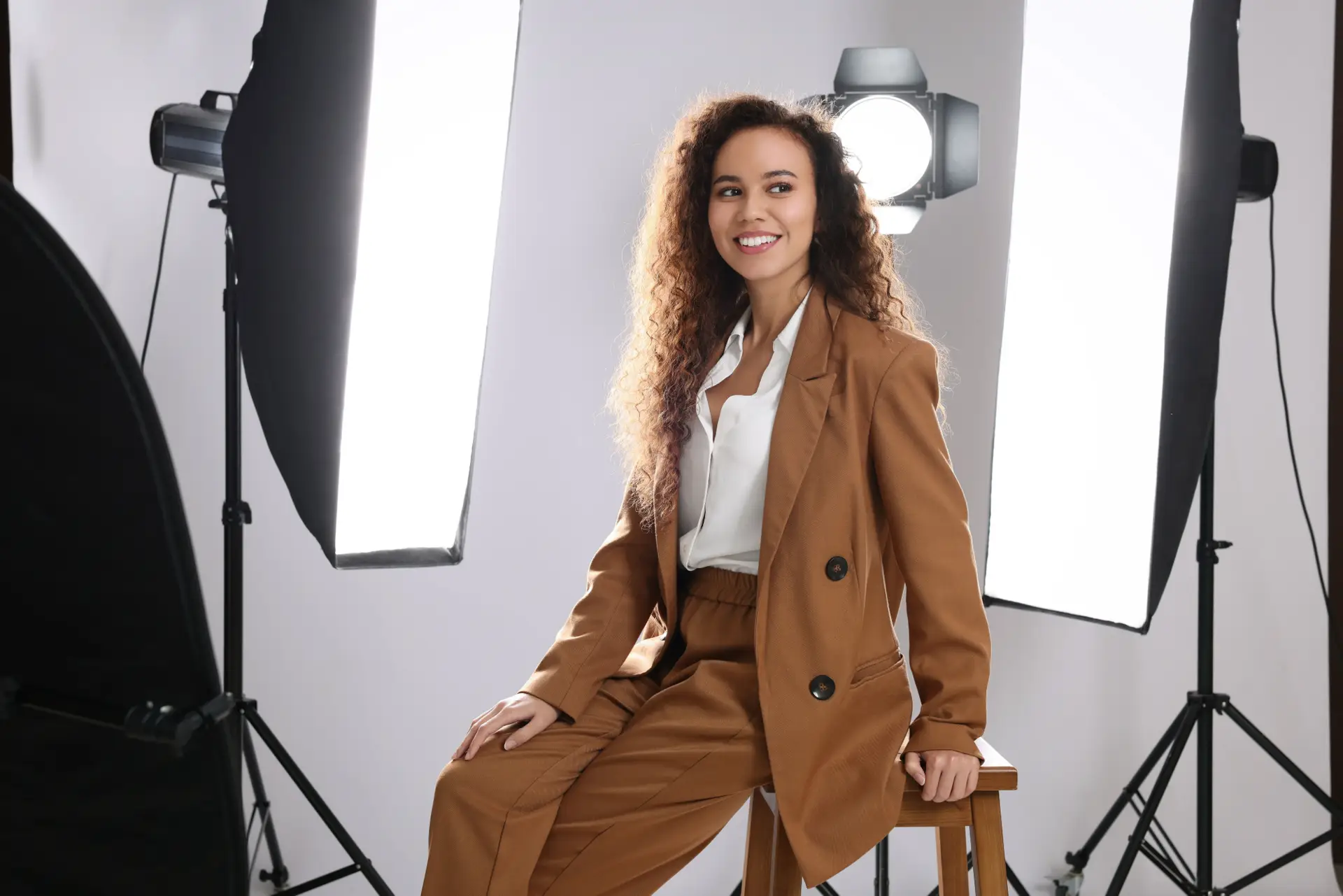 Jeune femme souriante posant en photo dans un studio professionnel avec éclairage moderne